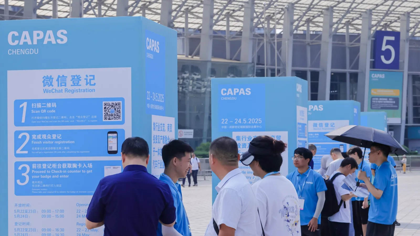Crowds of automotive industry professionals and visitors gathered near registration pillars at the CAPAS Chengdu trade fair under a bright, modern glass atrium. Image/Photo Credit: Messe Frankfurt